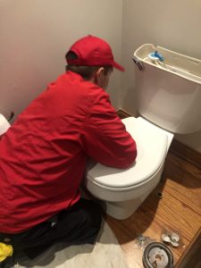 plumber working on toilet 